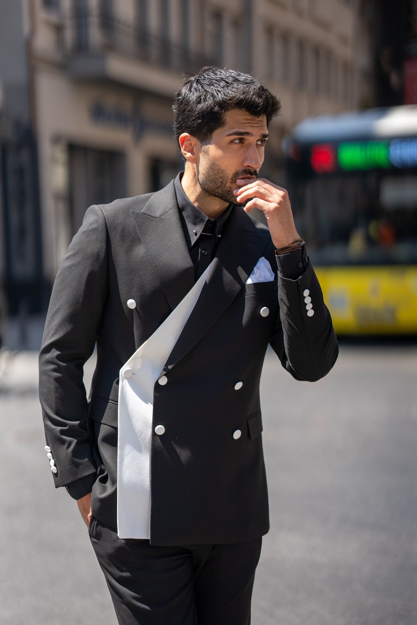 Man wearing a St. Tropez Black Slim Fit Double-Breasted Suit, styled with a white shirt and loafers, set against a luxurious coastal backdrop.