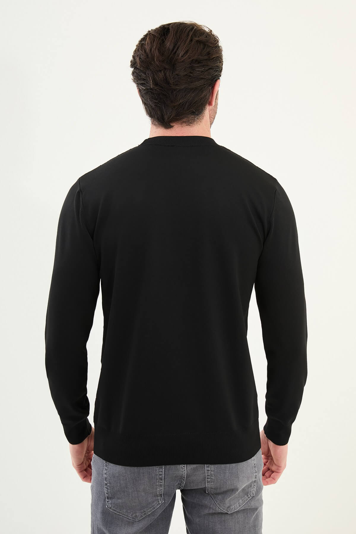 Men’s black textured crew neck sweater with geometric knit pattern, slim fit smart casual knit styled with gray jeans