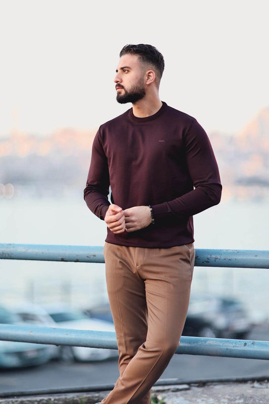 Men’s cherry long-sleeve knit sweatshirt styled with camel trousers outdoors
