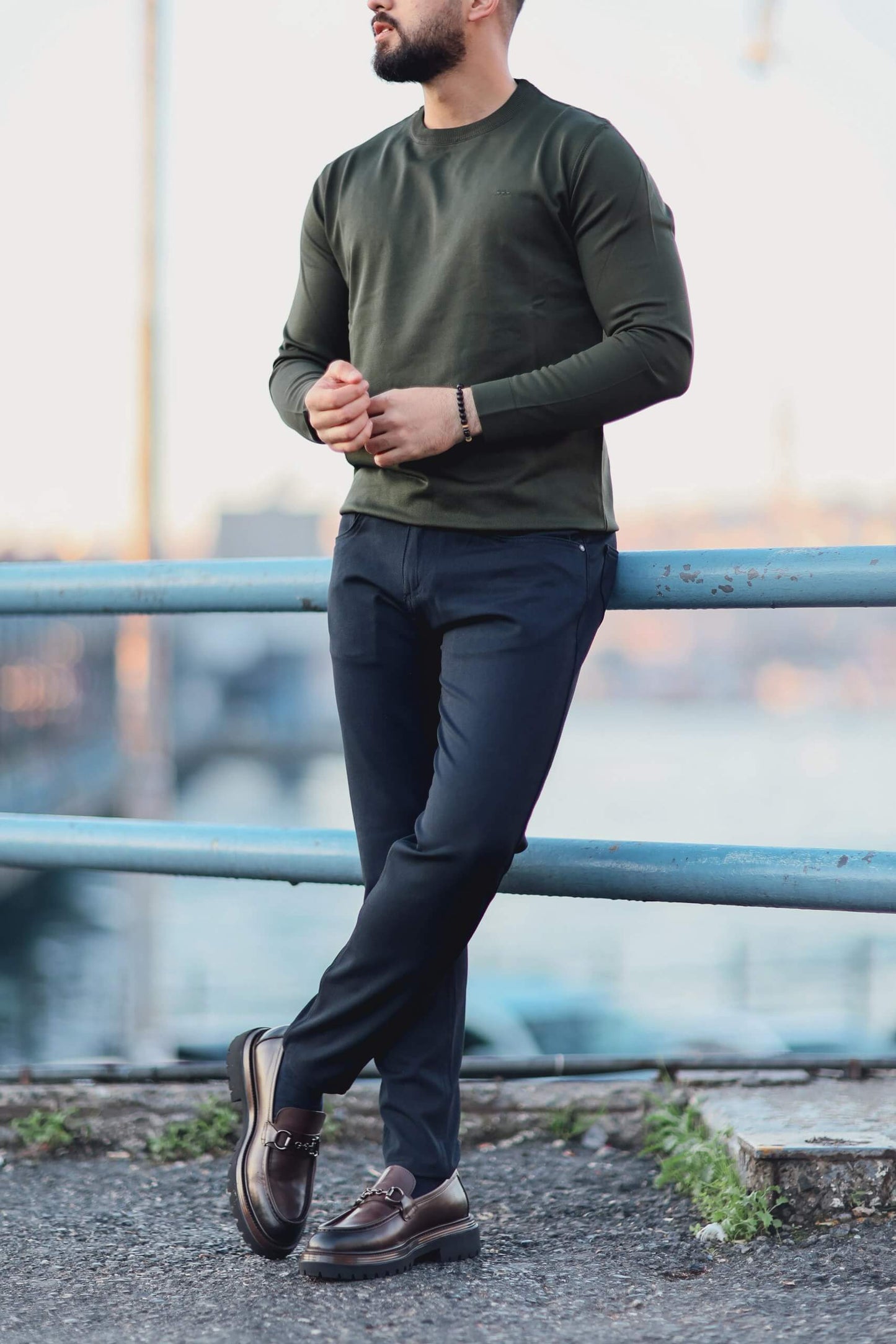 Men’s green long-sleeve cotton-blend polo sweater worn outdoors, showcasing fitted design and ribbed collar