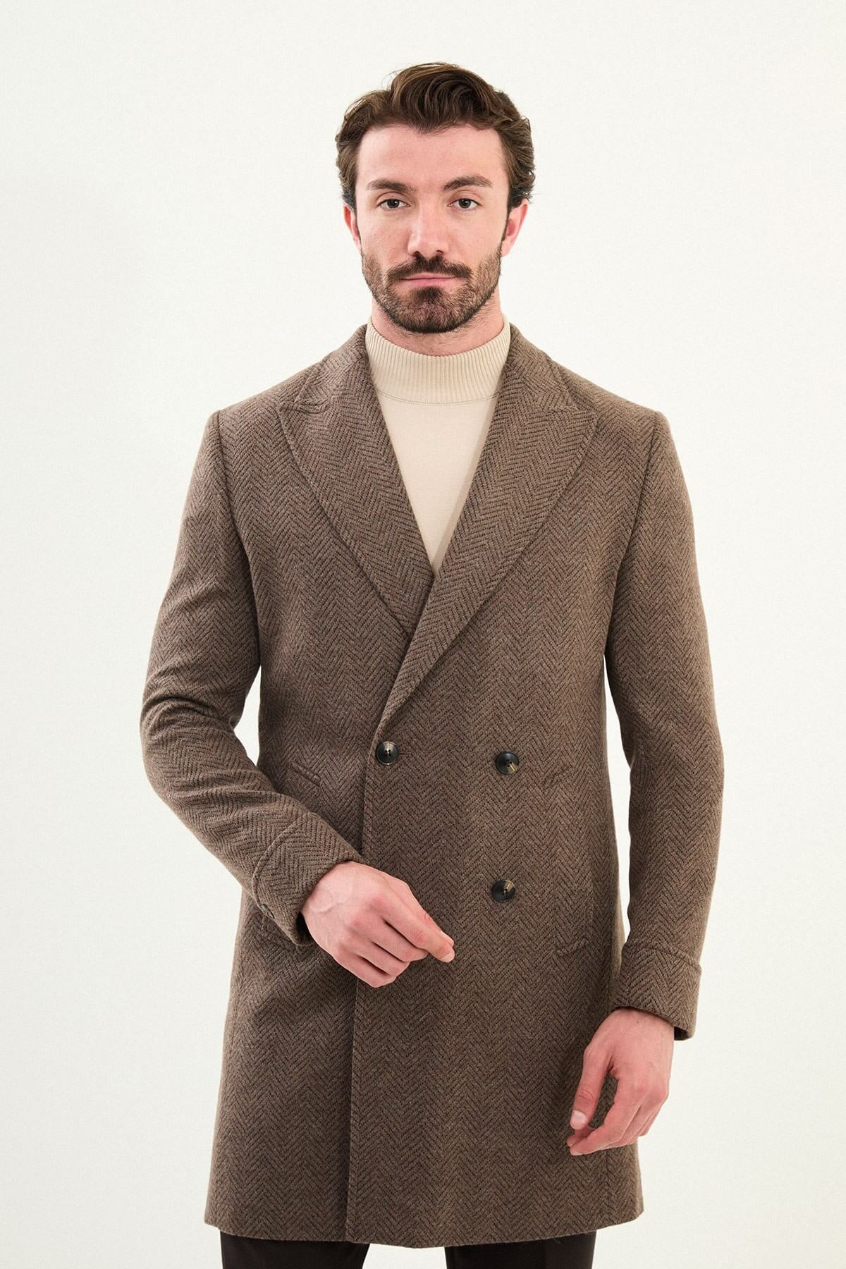 Full-body view of a man modeling a brown slim fit double-breasted coat with wide lapels, styled with dark trousers and brown Chelsea boots.