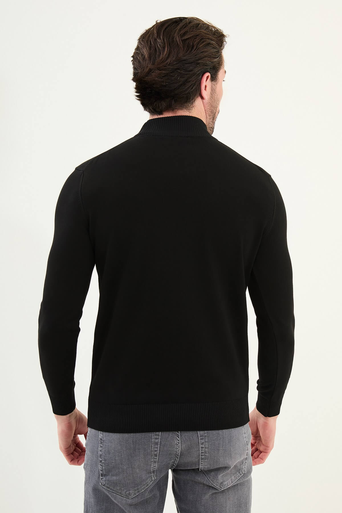 A men’s slim fit black half-turtleneck sweater with long sleeves, styled for the fall-winter season.