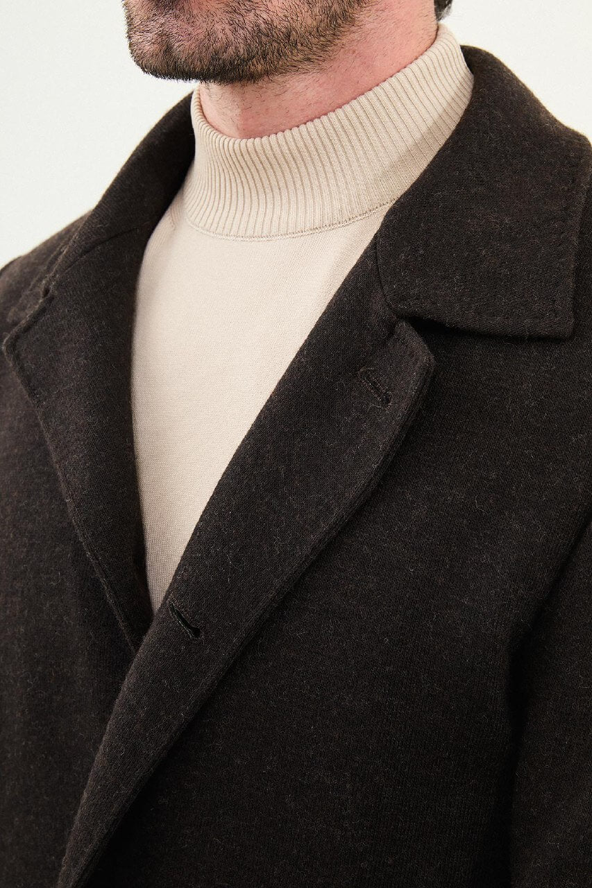 brown slim fit peacoat styled with beige turtleneck, brown trousers, and brown Chelsea boots.