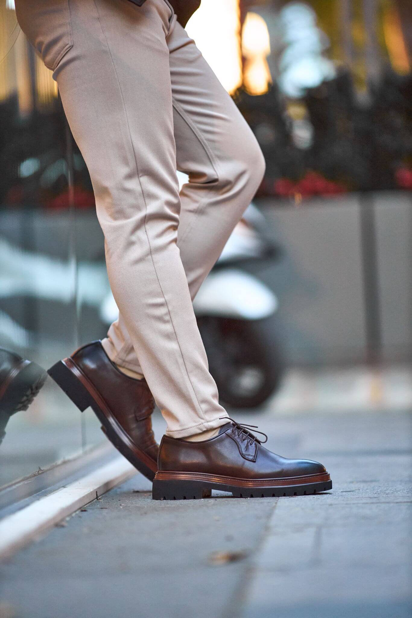 Men’s brown genuine leather chunky Derby shoes worn outdoors on pavement.