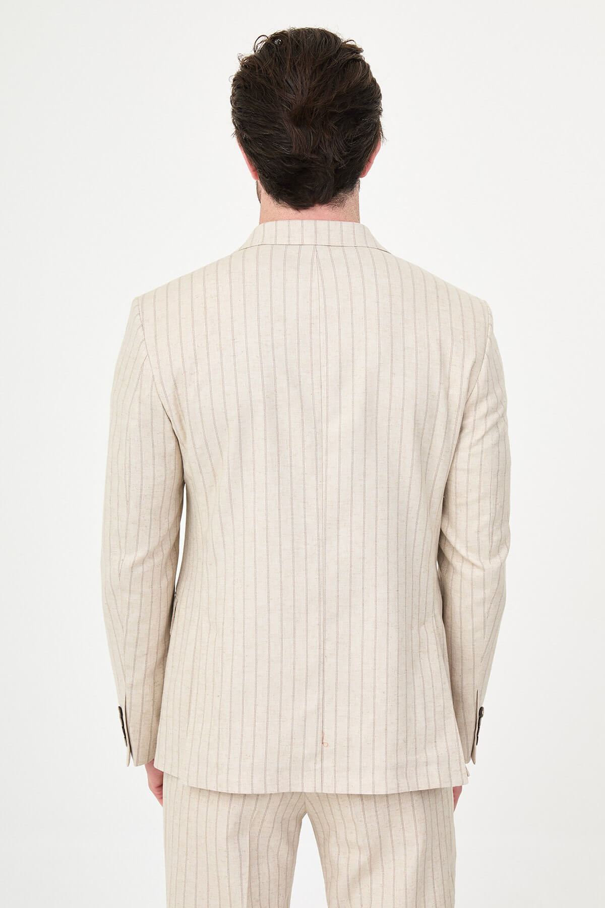 A man wearing a Beige Pinstripe Double-Breasted Slim-Fit Suit with a tailored fit, standing confidently.