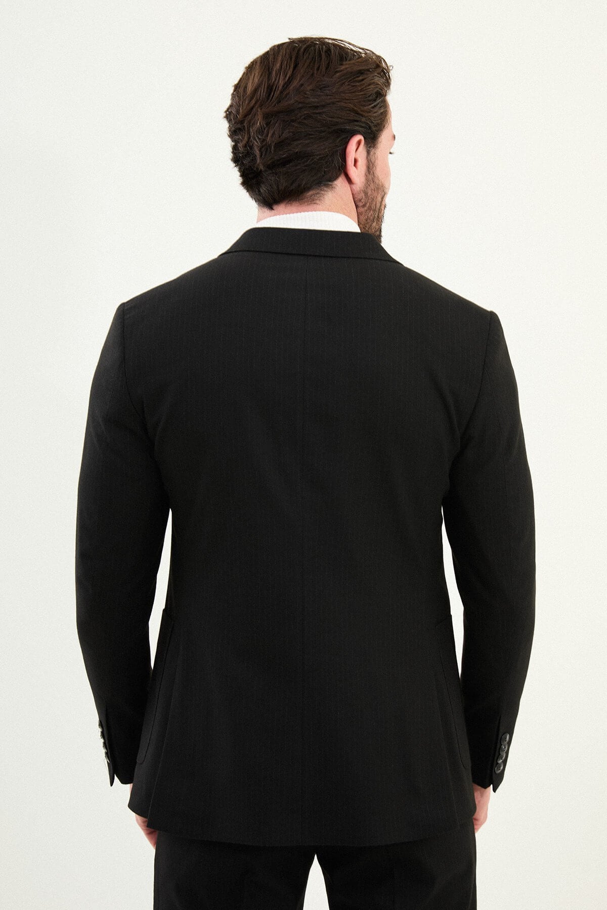 Men’s black mono-collar slim-fit suit with band/mandarin neckline, matte finish tailoring, single-breasted jacket styled with a white turtleneck, travel-ready stretch wool-viscose blend.