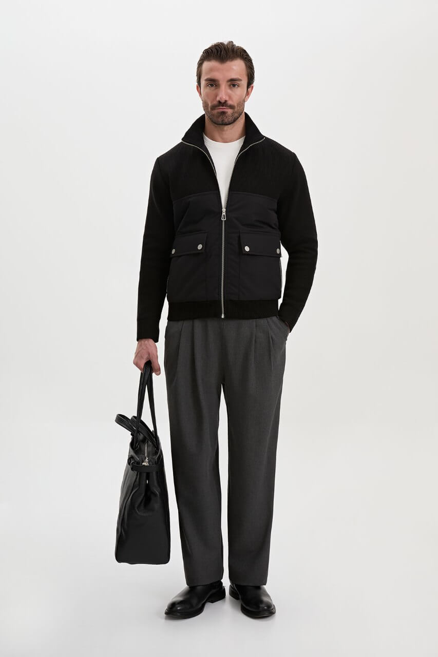 Black men's casual jacket styled with a white T-shirt and grey trousers.