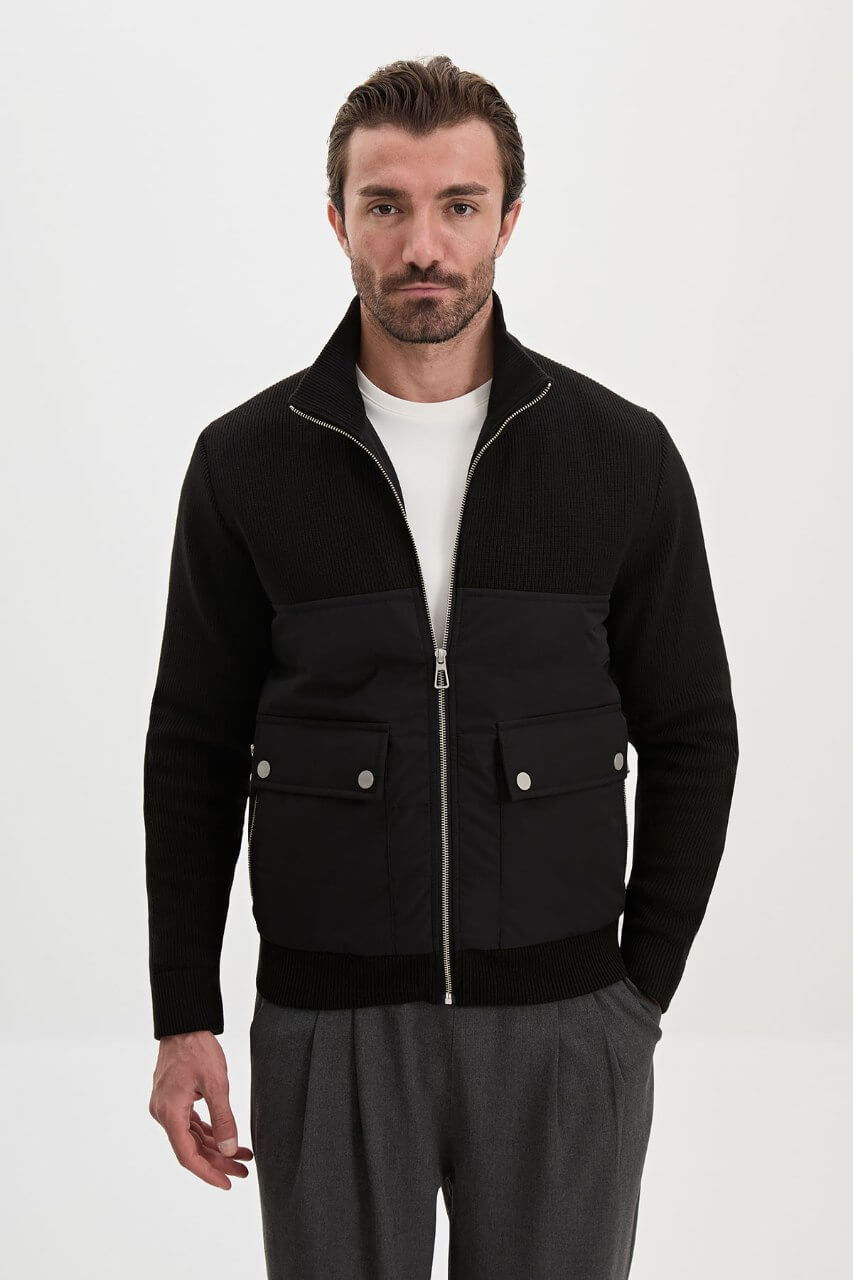 Black men's casual jacket styled with a white T-shirt and grey trousers.