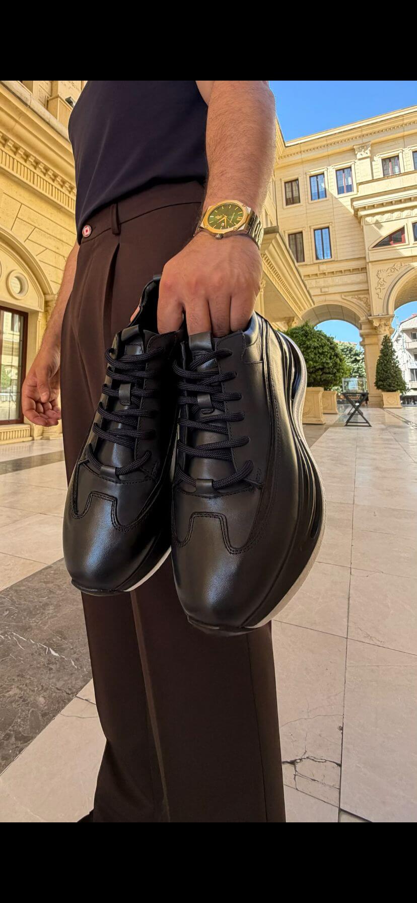 Pair of men's black leather low-top sneakers, full view