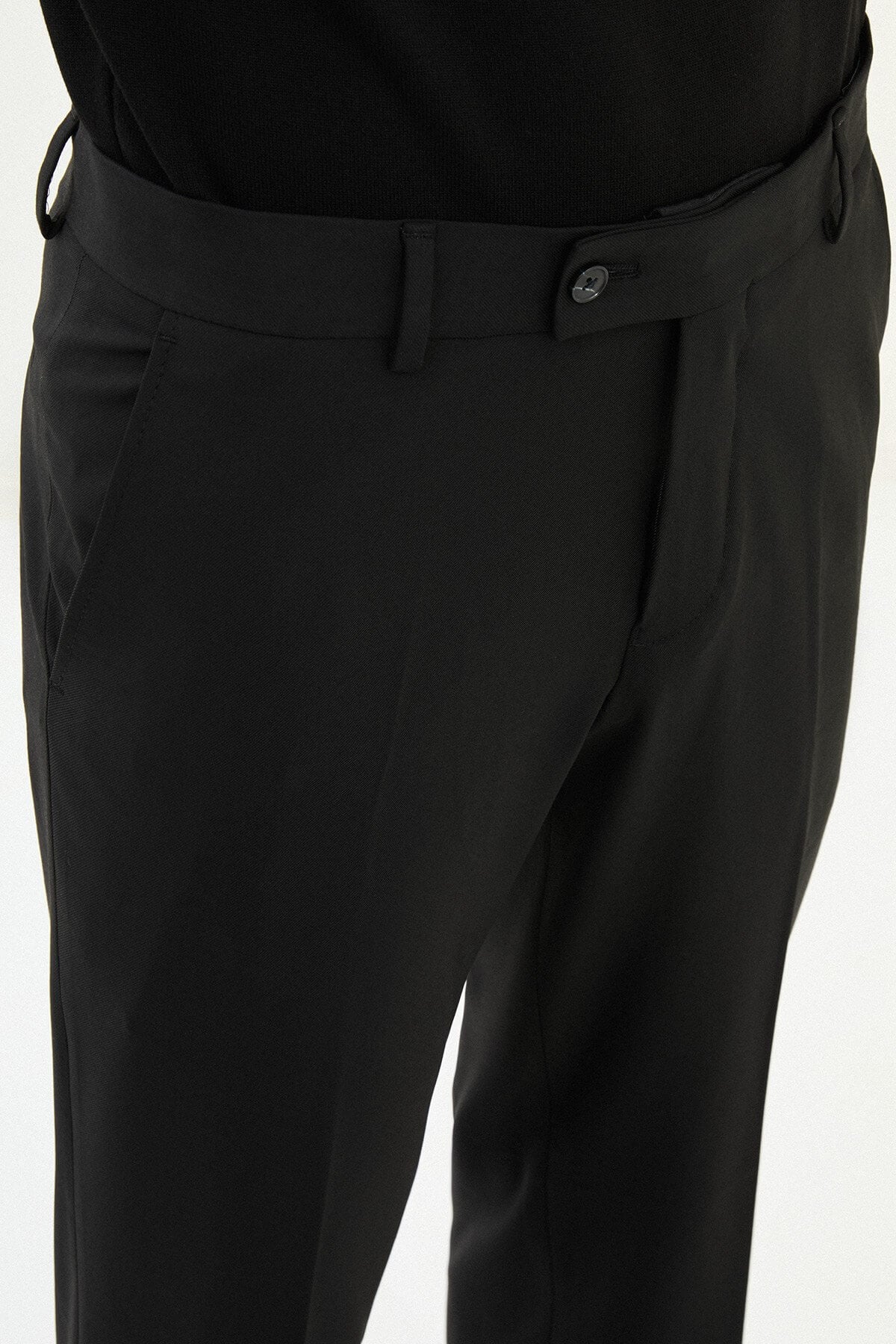 Men wearing black slim-fit classic trousers, styled with formal shoes, suitable for business and formal events.
