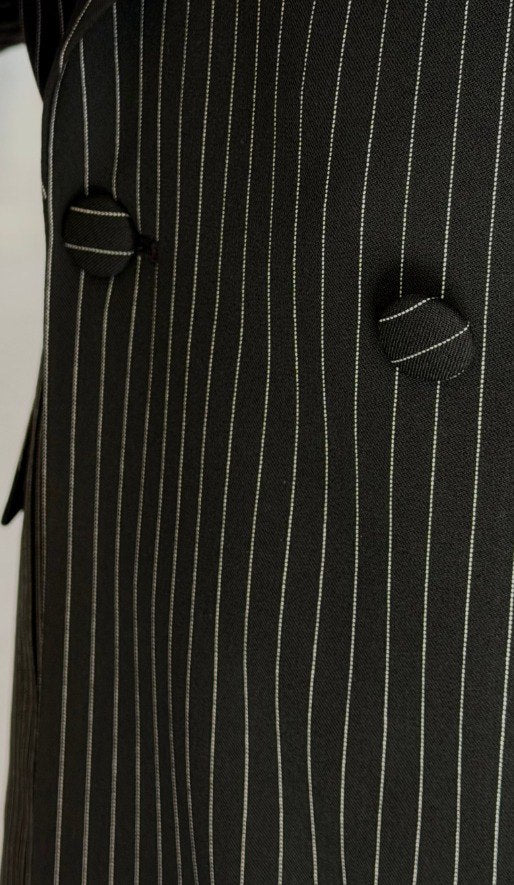 Black pinstripe double-breasted men’s suit styled with black loafers