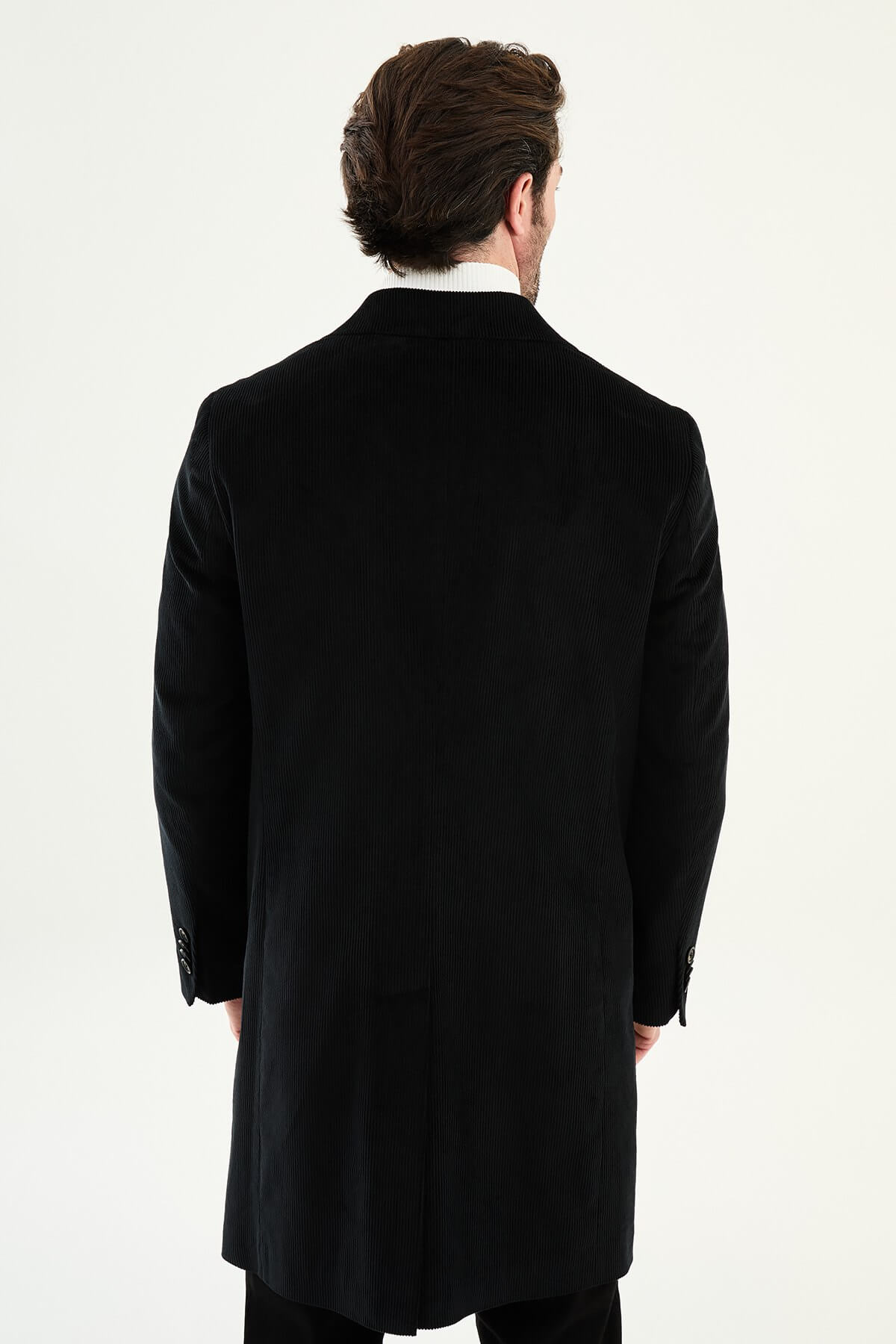 Black double-breasted men’s coat styled with white turtleneck sweater
