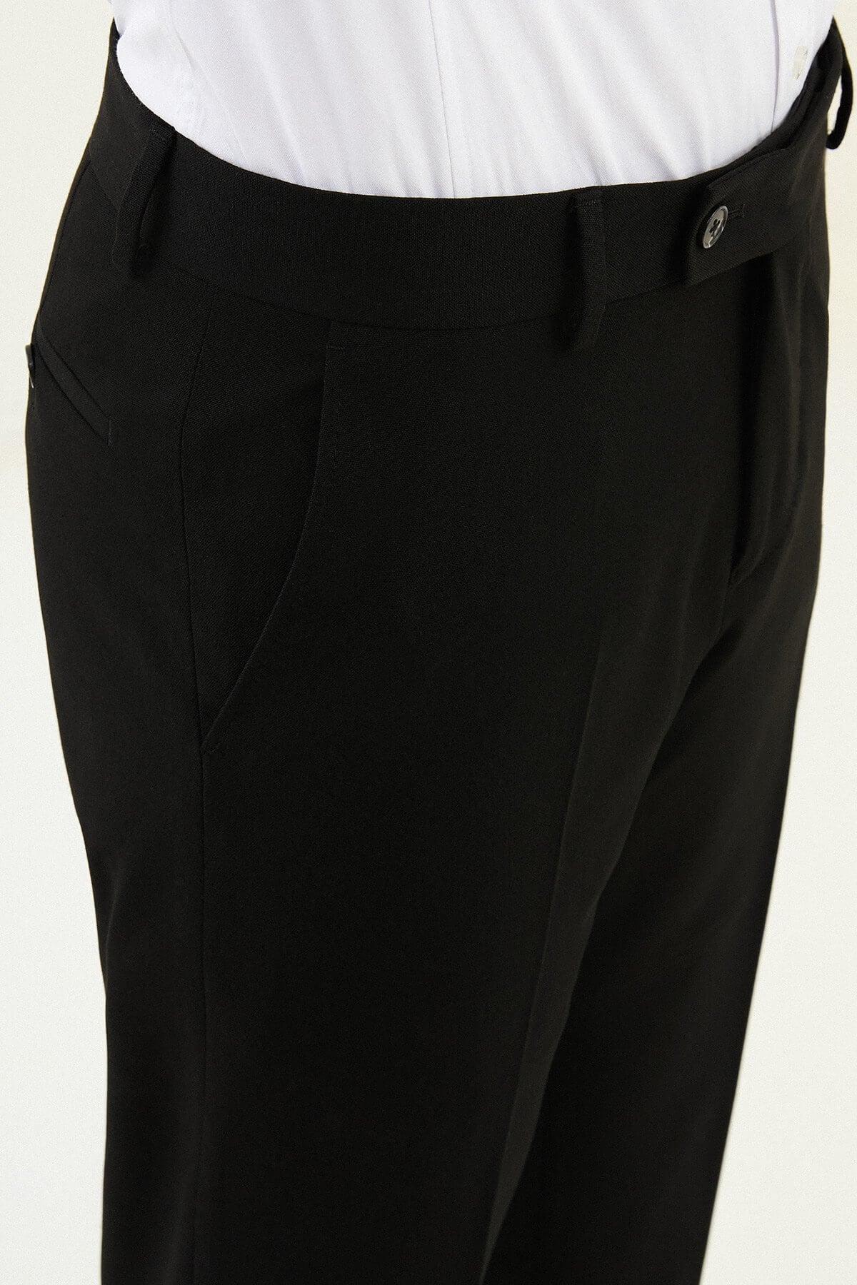 Black slim-fit formal trousers with front pleats, styled with black leather shoes.