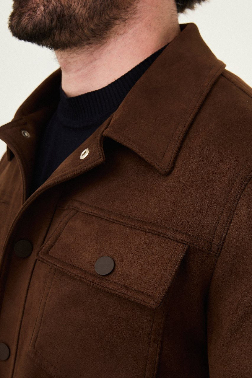Men's brown suede-style jacket paired with a black sweater and beige trousers.
