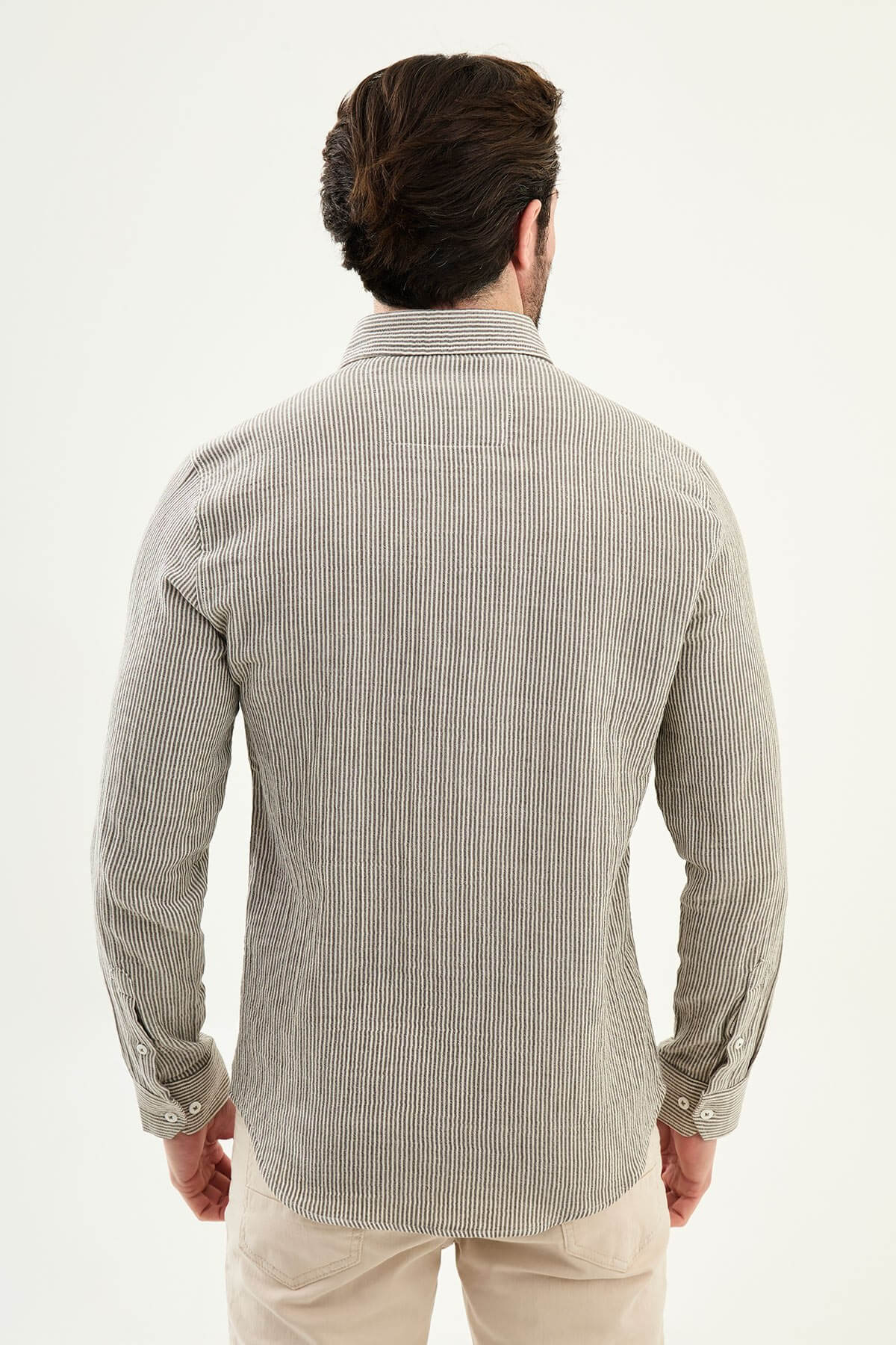 Men wearing a brown slim-fit long sleeve cotton shirt with a chest pocket, standing casually, showcasing the tailored fit and fabric texture.