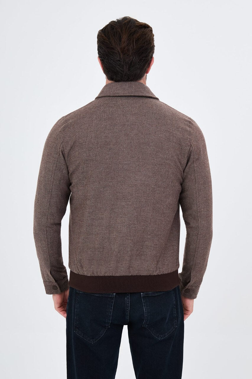 Brown men's casual jacket styled with a black sweater and dark jeans.