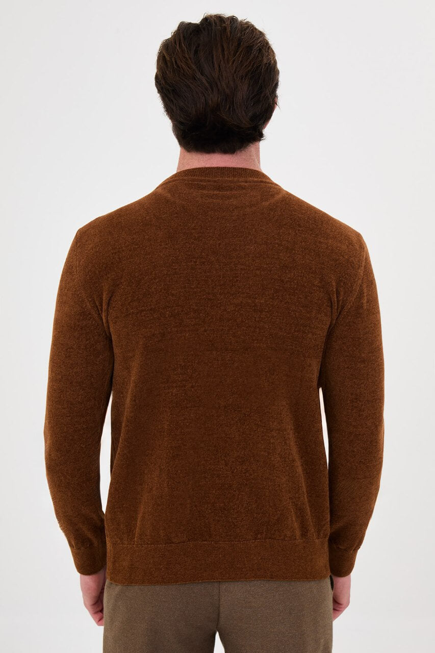 Men’s camel crew neck knit sweater in a cotton blend slim fit design styled with brown trousers for a refined fall winter outfit.