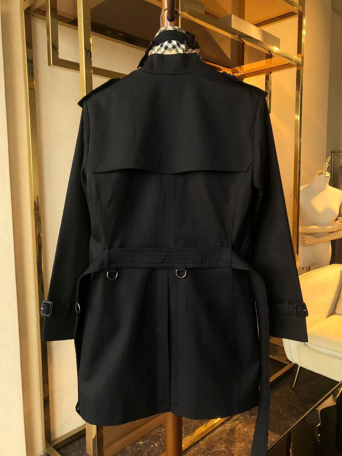 Black trench coat with a double-breasted design and adjustable belt