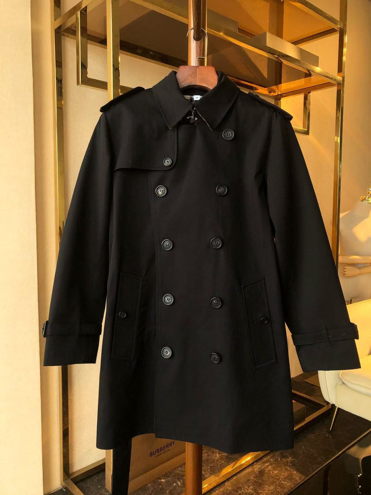 Black trench coat with a double-breasted design and adjustable belt