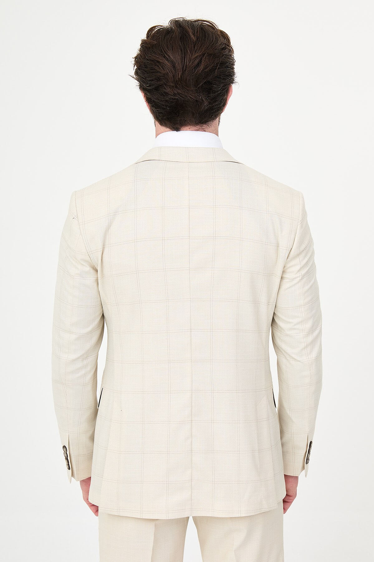 an ecru check slim-fit three-piece suit with matching waistcoat and trousers, white dress shirt, dark brown tie, and brown leather Derby shoes.