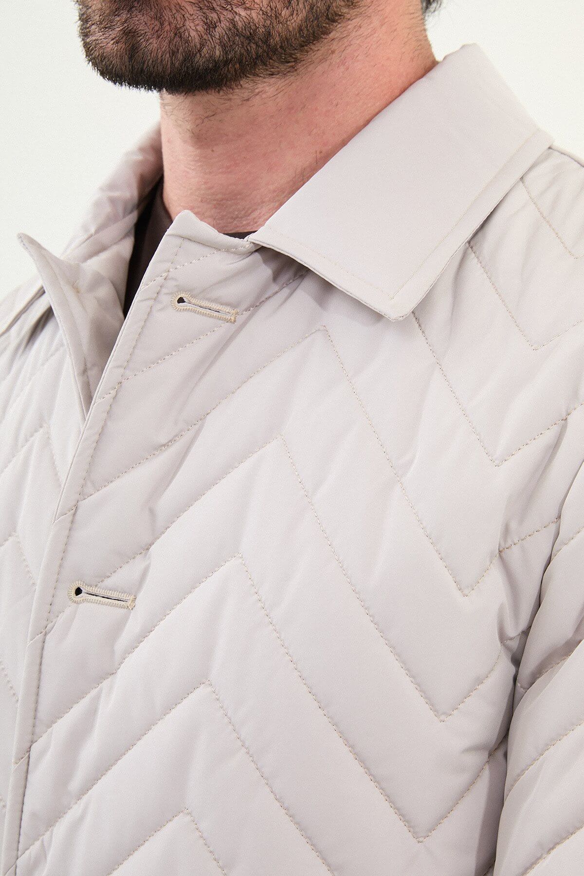 Men’s Ecru Quilted Slim Fit Car Coat with chevron stitching and button closure, styled with dark brown trousers and beige sneakers.