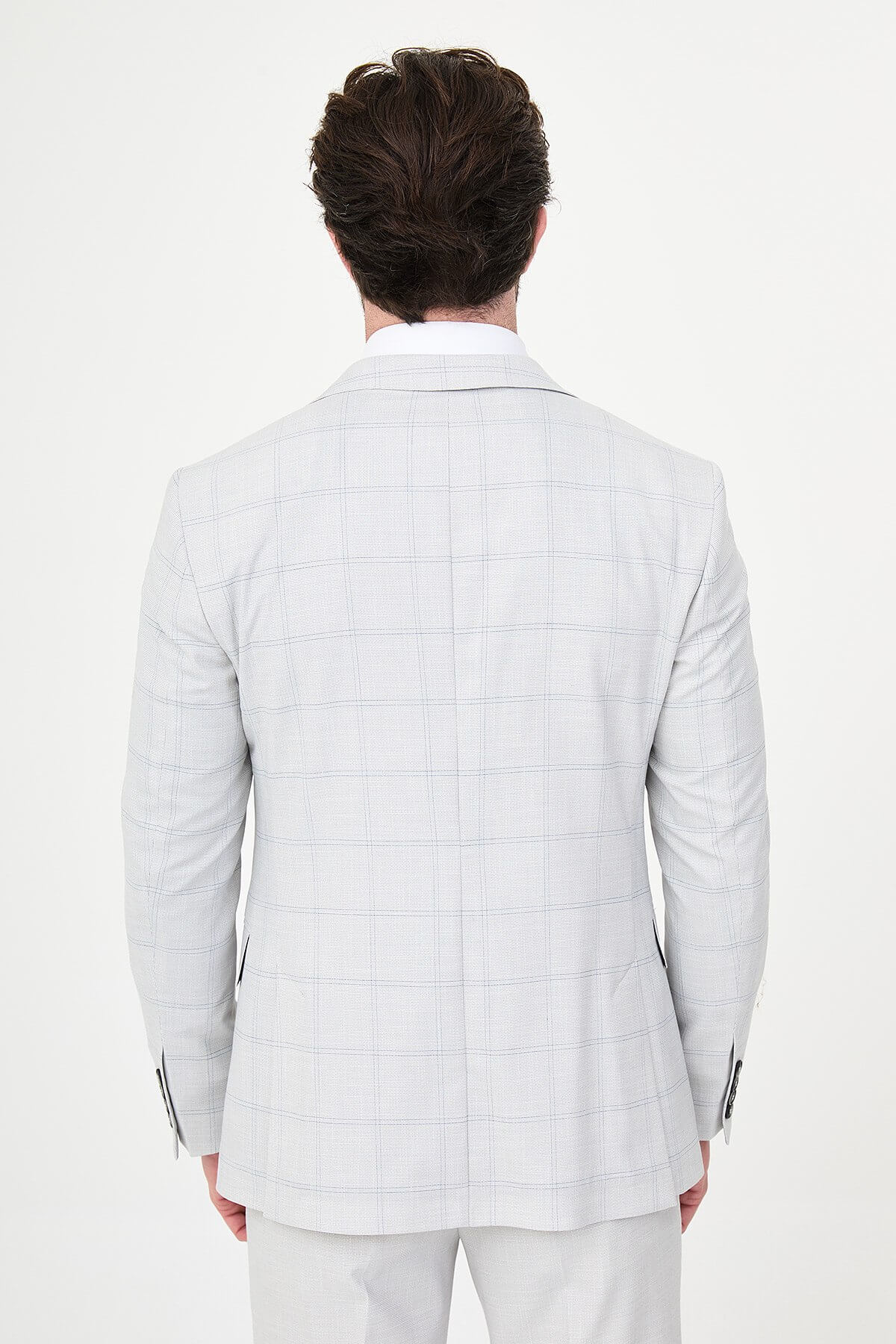 a gray check slim-fit three-piece suit with matching waistcoat and trousers, white dress shirt, royal-blue tie, and black leather Derby shoes.