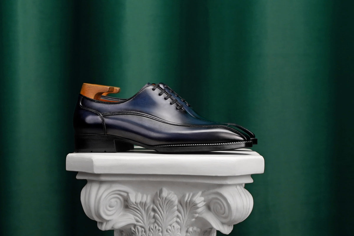 Men’s navy blue leather Oxford dress shoes with polished finish, lace-up design, sleek pointed toe, and elegant formal silhouette.