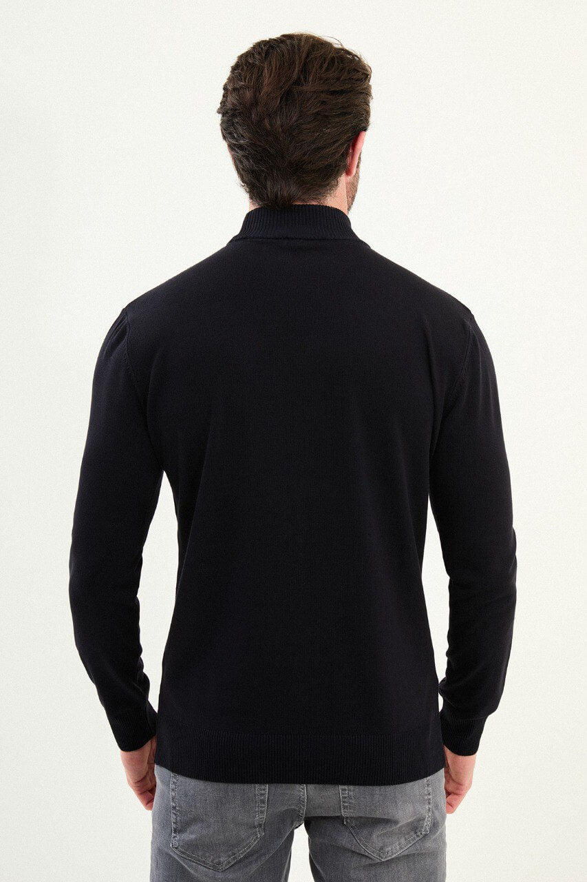 Men’s navy blue slim-fit ribbed mock-neck cotton-blend sweater with multi-directional ribbing and diagonal chest panels, styled with light gray denim.