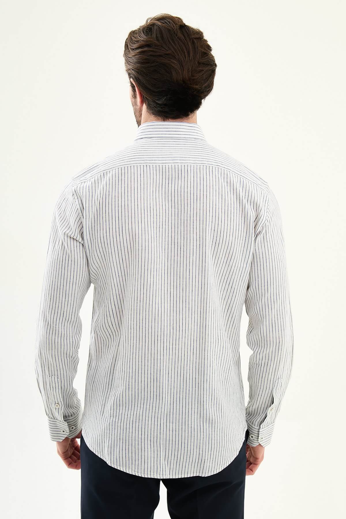 Men wearing a navy blue slim-fit long sleeve shirt with contrast pocket, styled in casual smart summer outfit.