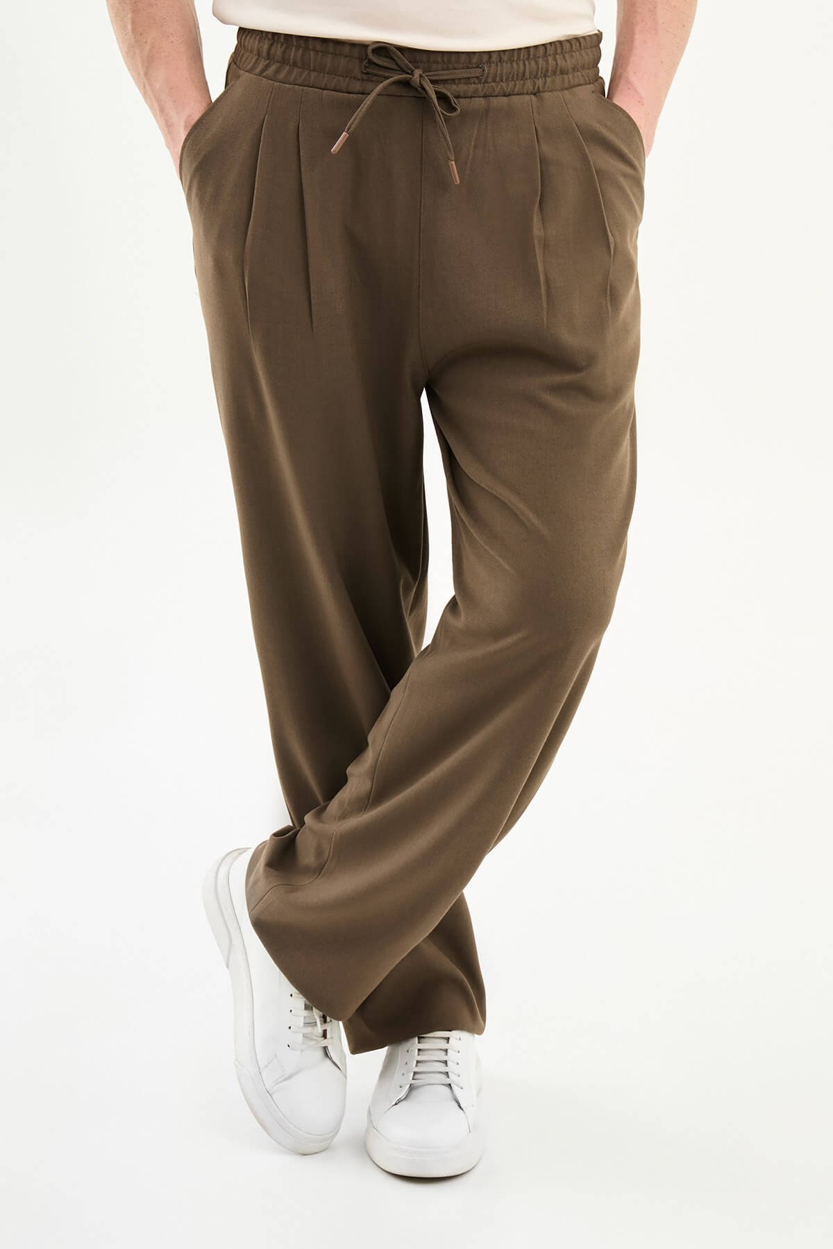 Men wearing olive brown luxe drawstring jersey pants with brown dress shoes, styled for a relaxed smart-casual summer look.