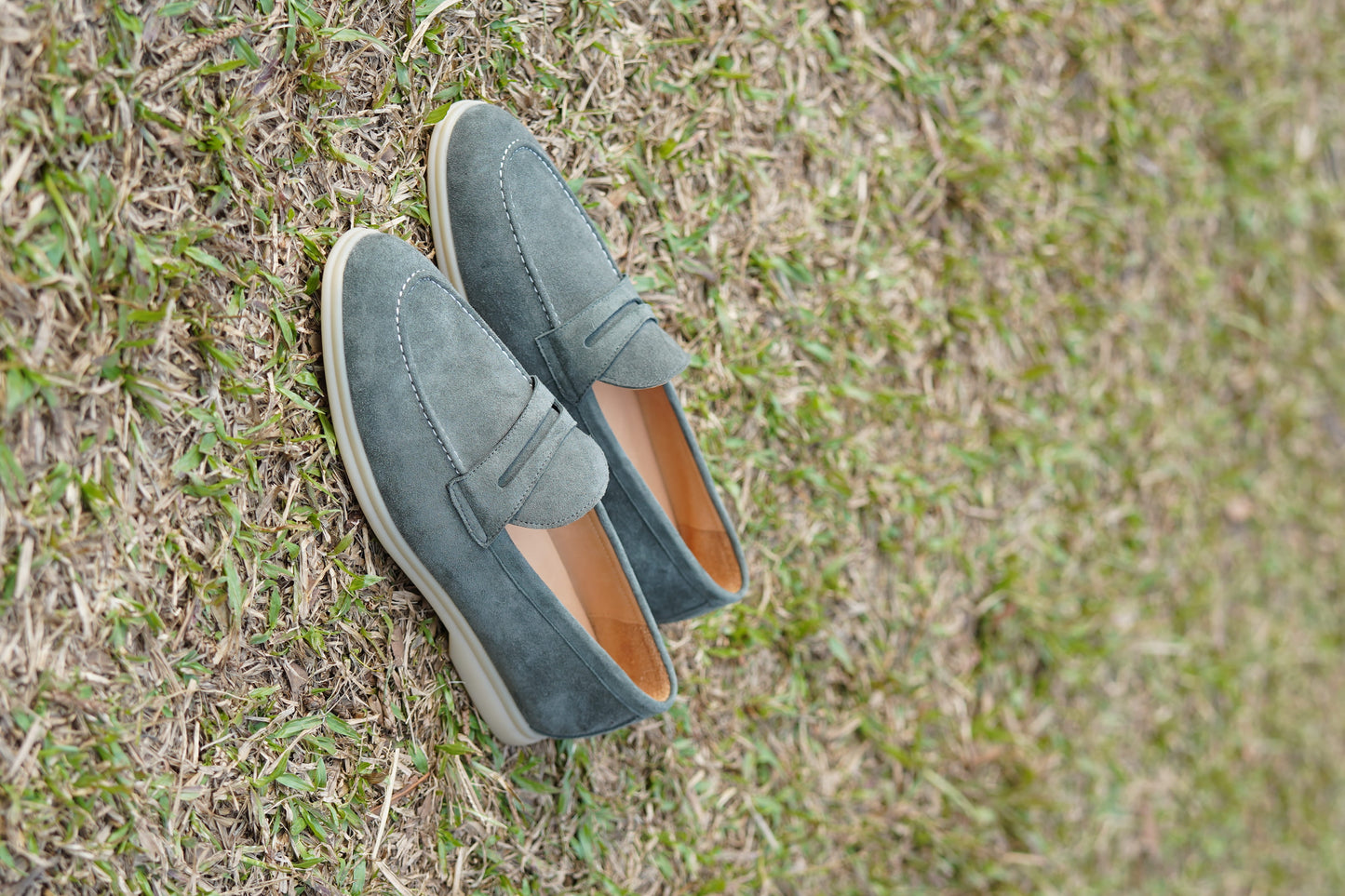 Men’s pale cyan mist suede leather penny loafers with classic strap detail and lightweight cream sole.