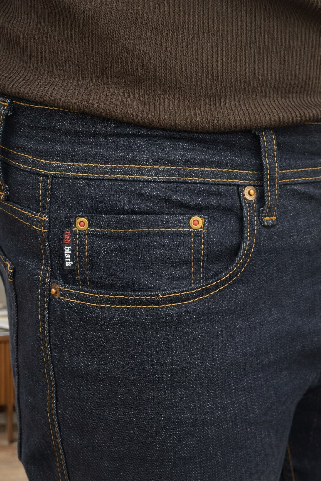 Dark blue slim straight men’s jeans styled with brown knit sweater and leather loafers