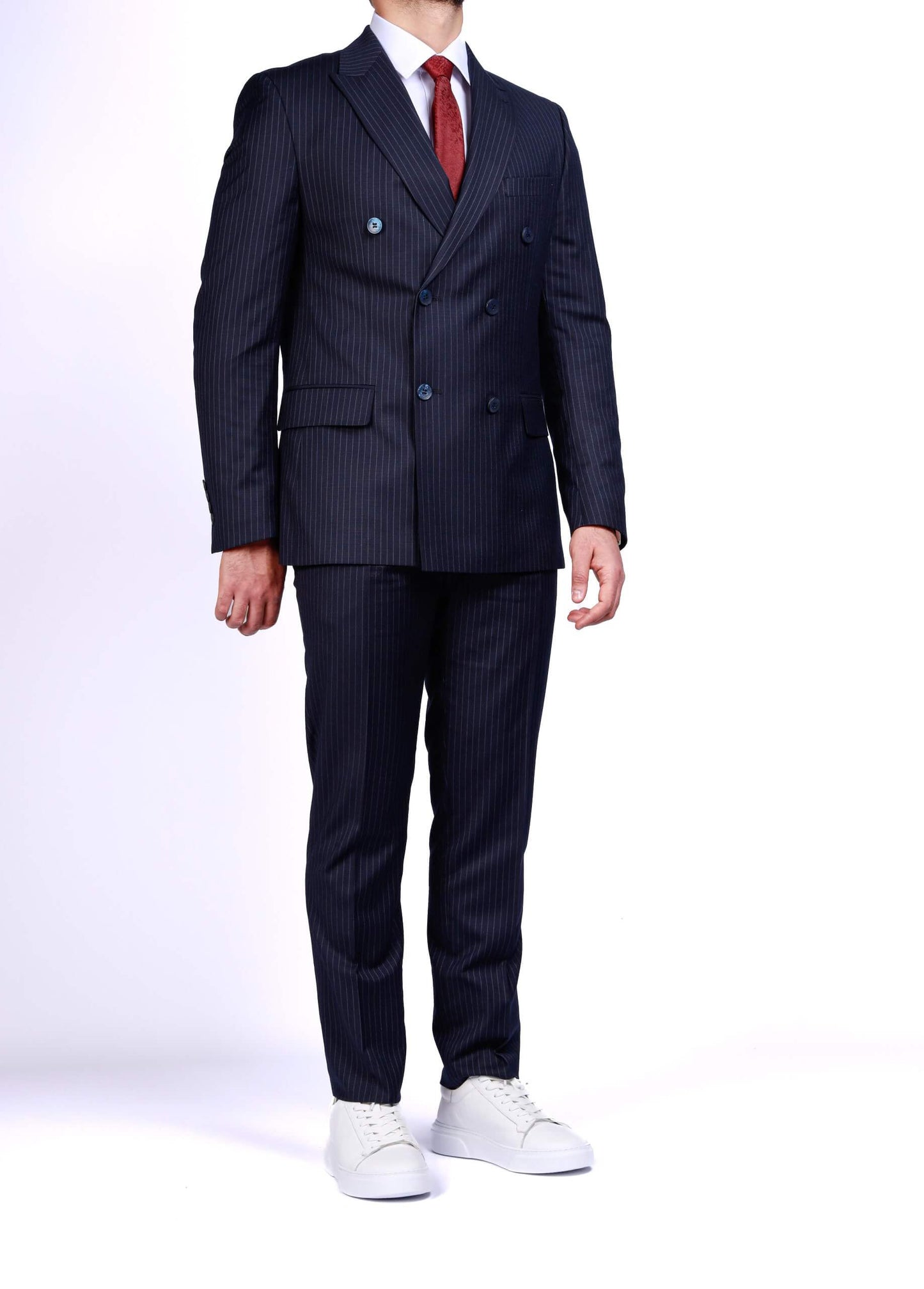 Men’s dark blue double-breasted pinstripe suit with peak lapels and slim-fit tailoring, worn with white shirt and red tie.