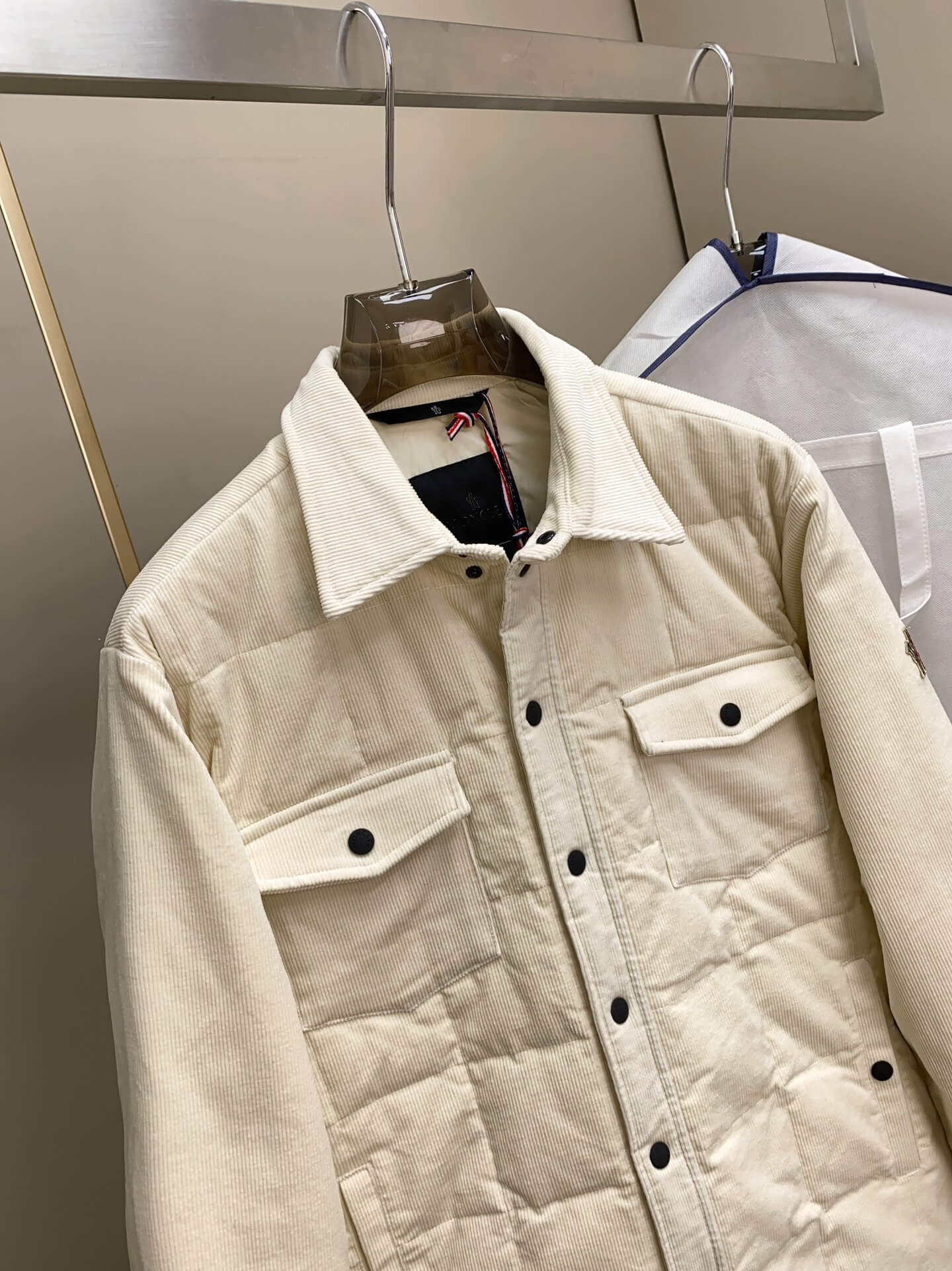Cream corduroy down shirt jacket with quilted lining and buttoned chest pockets, Moncler-inspired design.