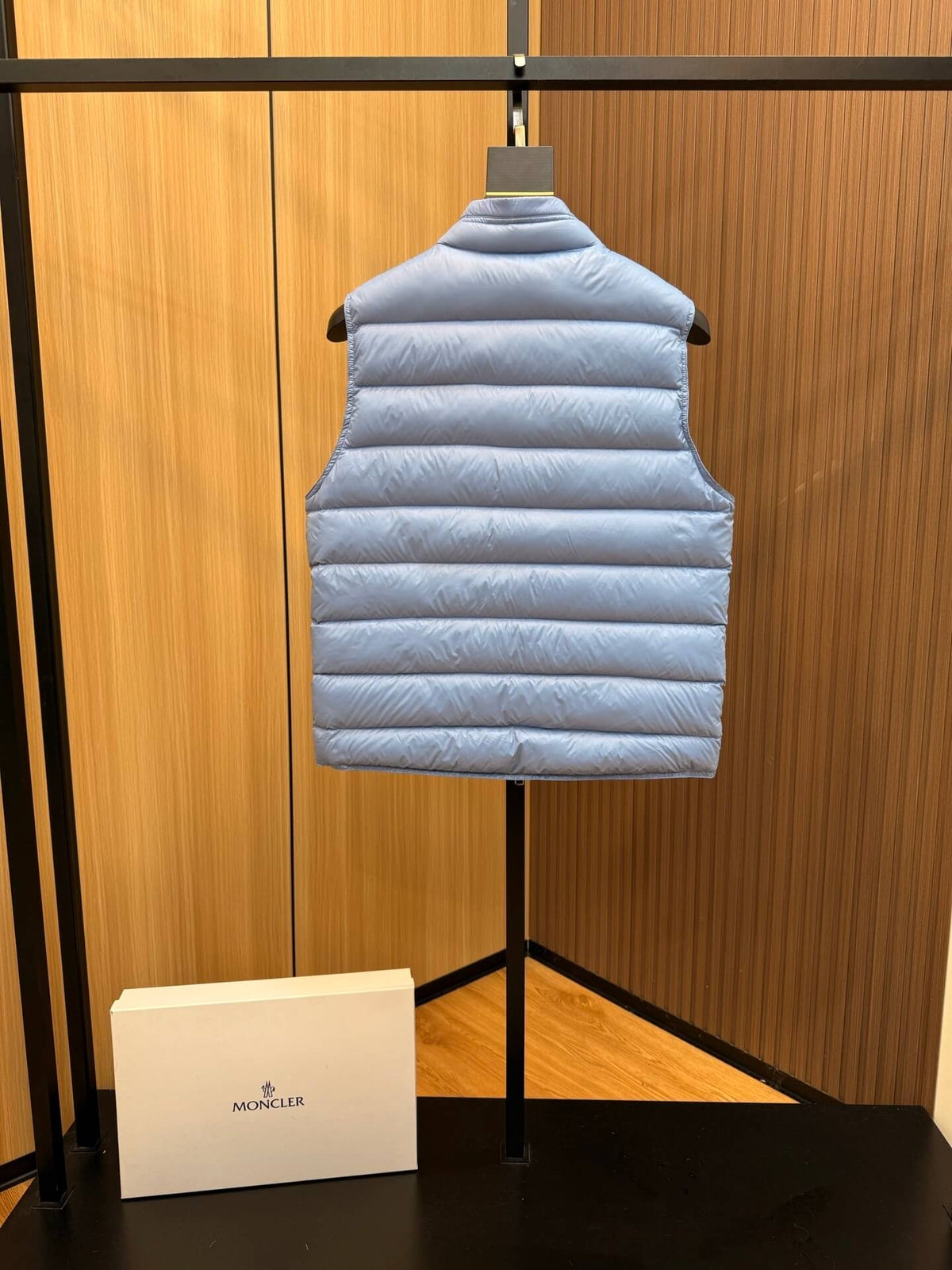 Light blue glossy down vest with chest logo patch and quilted panels, Moncler Gui-inspired.