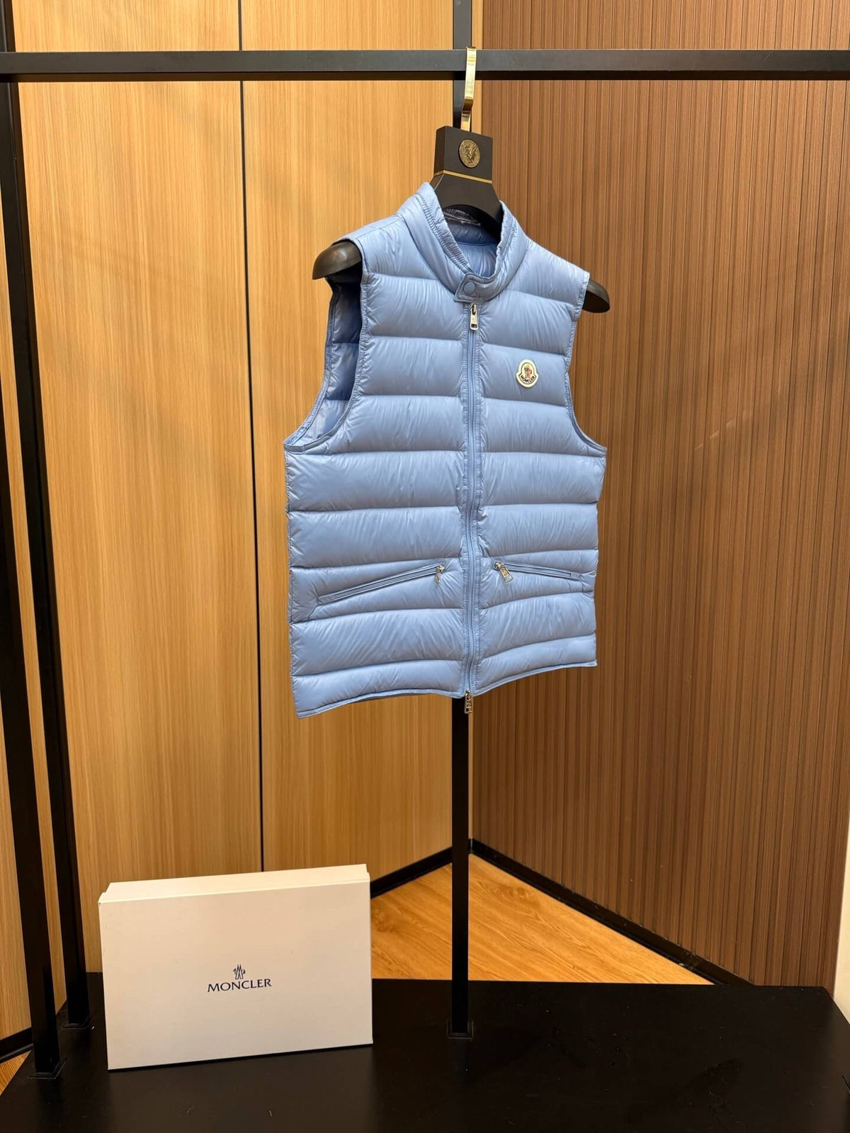 Light blue glossy down vest with chest logo patch and quilted panels, Moncler Gui-inspired.
