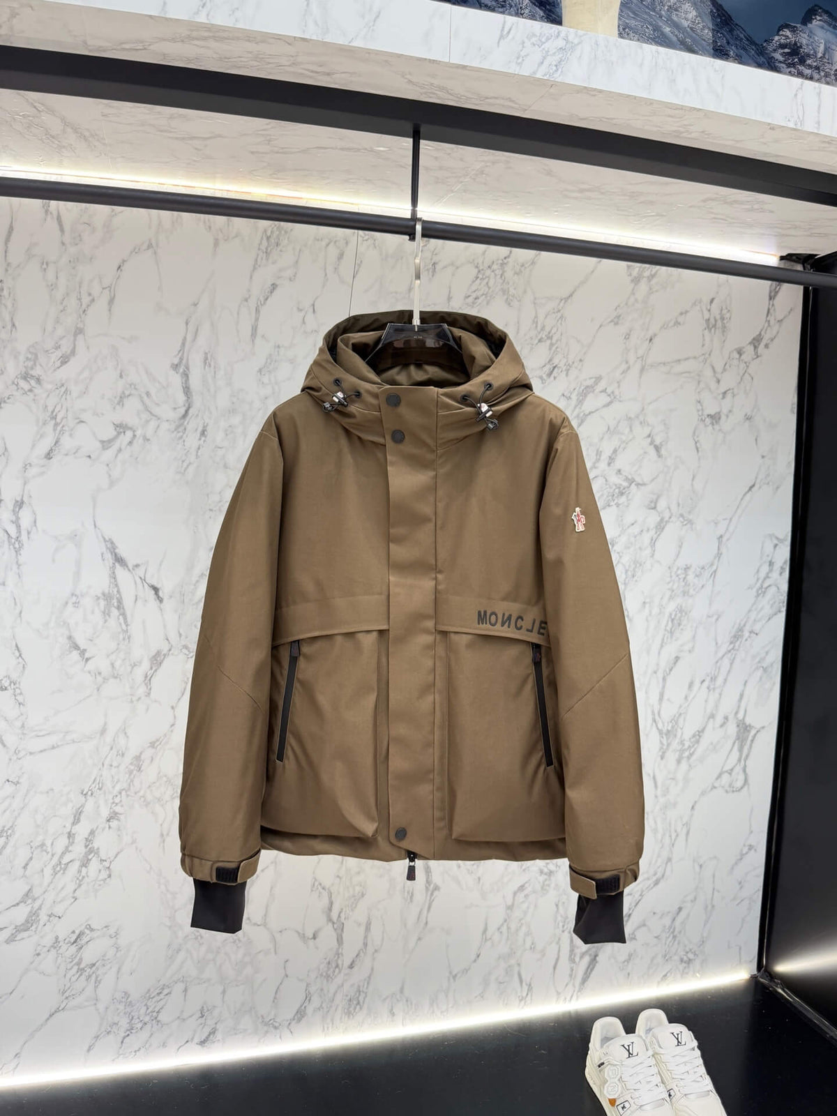 Brown hooded technical jacket with front snap closure and zippered pockets, Moncler-inspired design