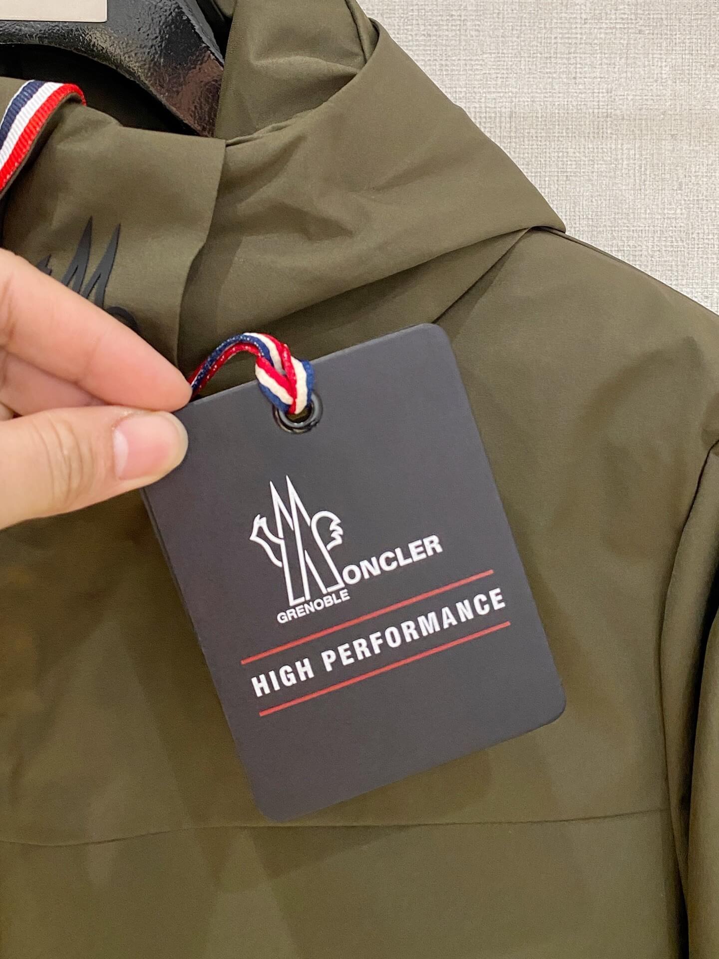 Olive-green hooded technical down jacket, unzipped to show black quilted lining and snow-skirt; Moncler-inspired design