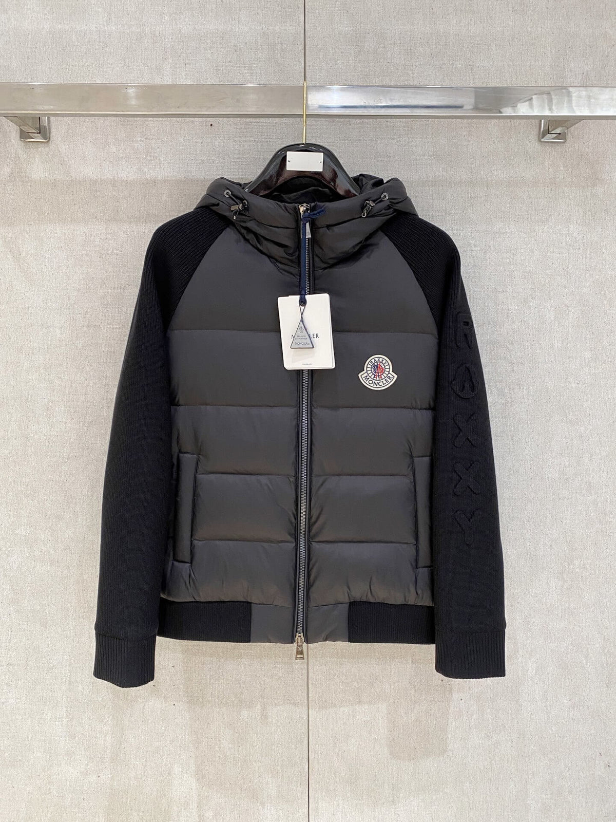 Black knit-sleeve down jacket with quilted front panels and hood, Moncler x Christopher Raxxy inspired design.