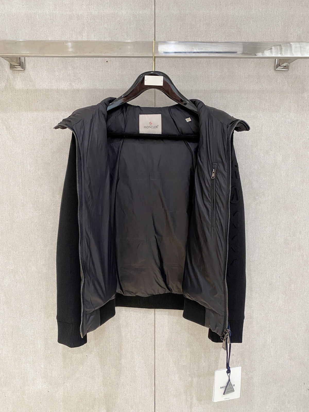 Black knit-sleeve down jacket with quilted front panels and hood, Moncler x Christopher Raxxy inspired design.