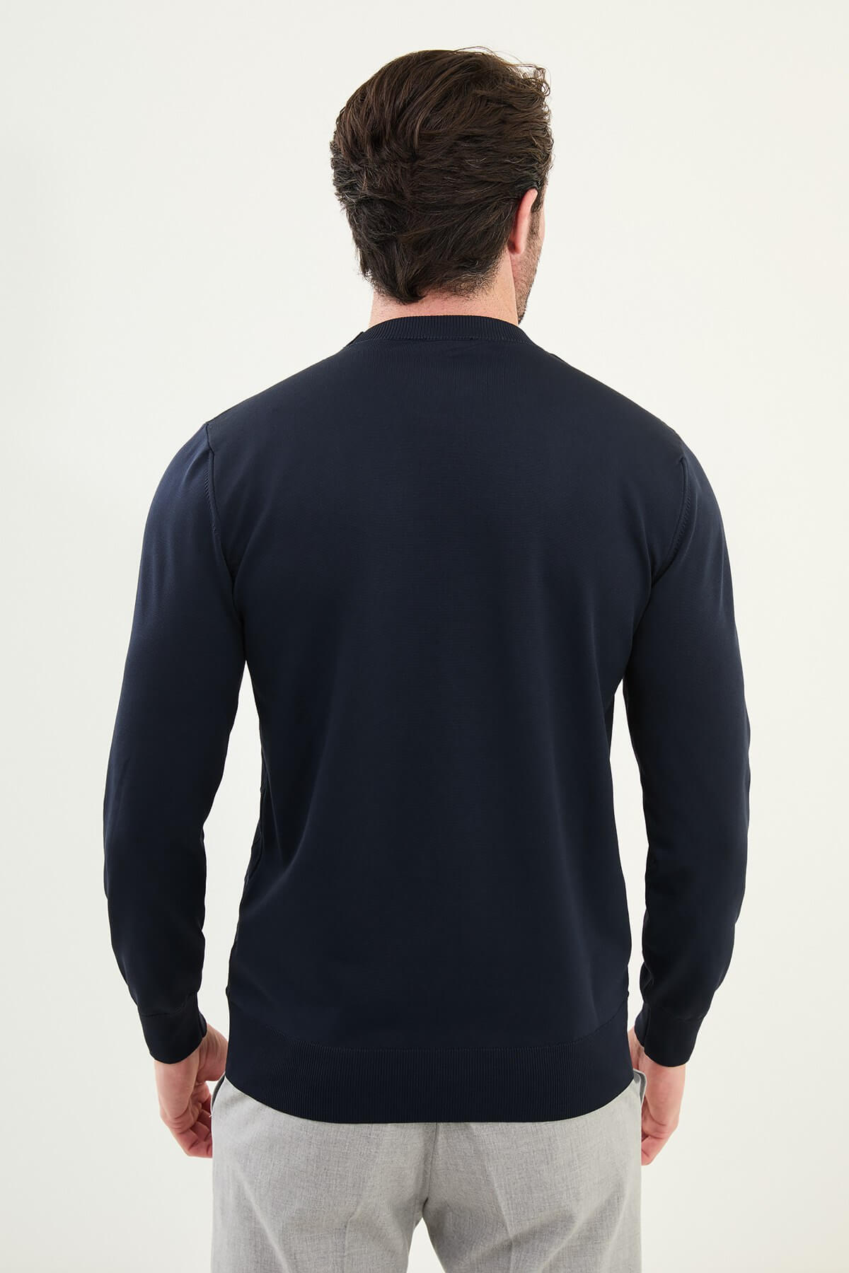 Men’s navy blue textured crew neck sweater with geometric knit pattern, slim fit smart casual knit styled with light gray trousers