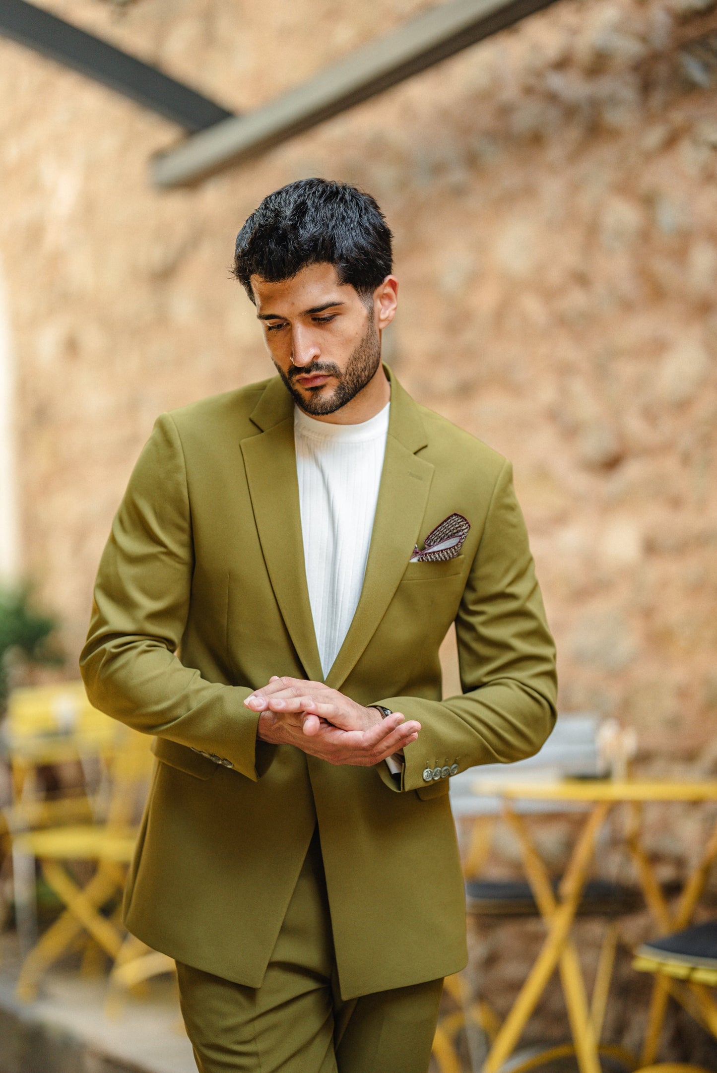 Man wearing the Bora Bora Olive Green Luxury Chain Detailed Suit with a white shirt and loafers, styled against a tropical summer backdrop.