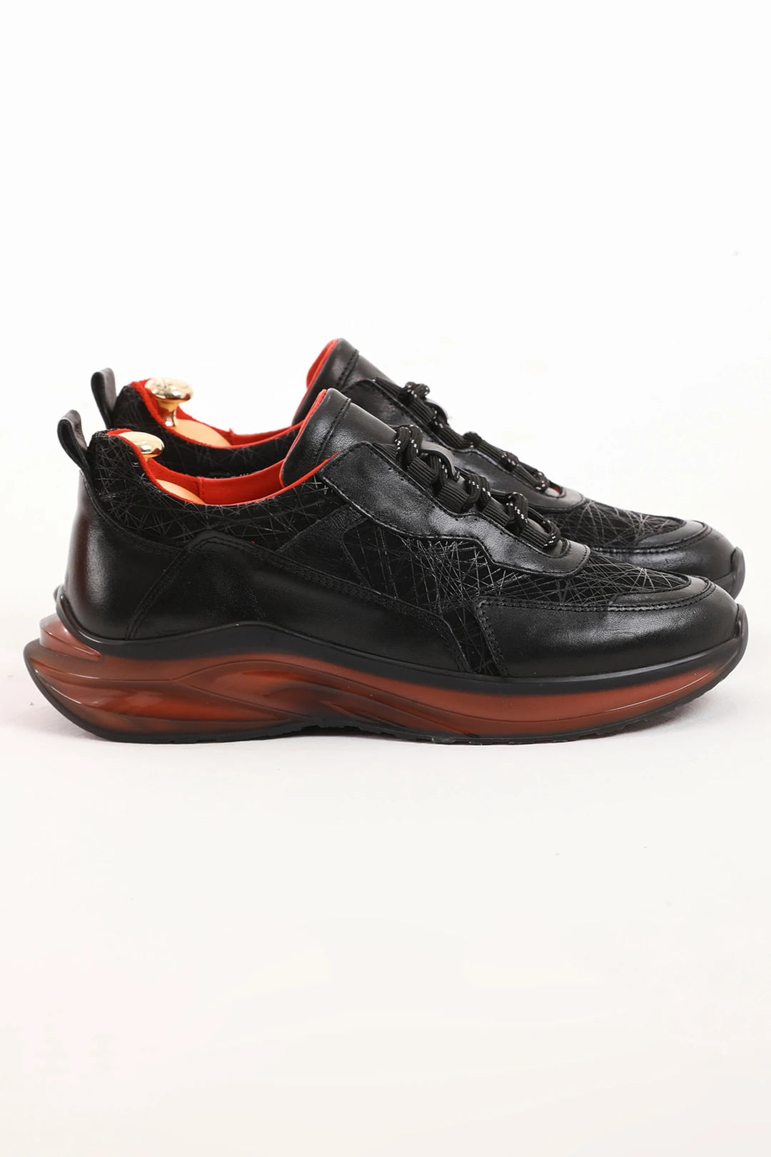 Black leather streetwear sneaker with red sole accents, side view