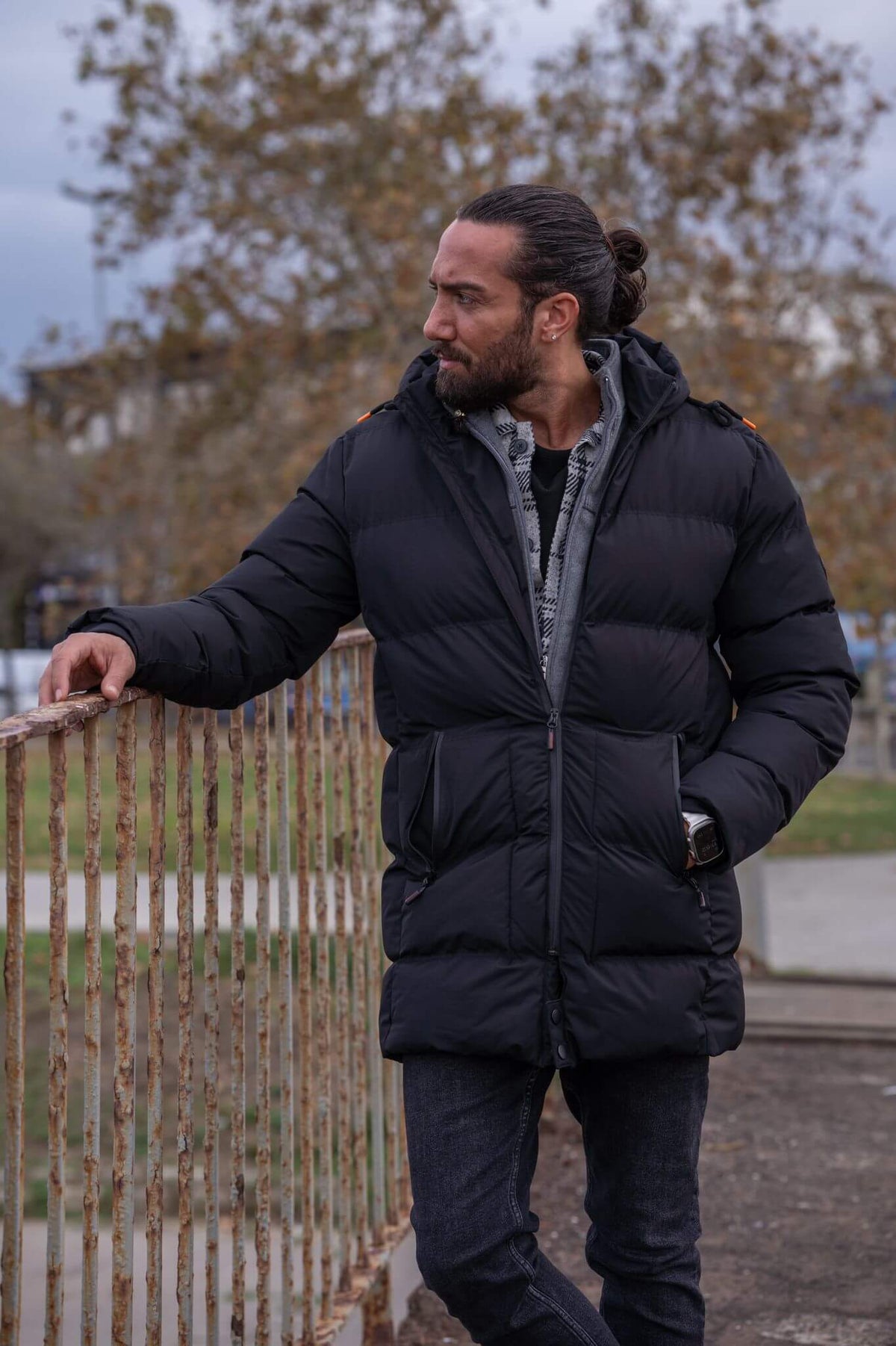 Striking male model confidently displays the sleek and stylish black puffer jacket.