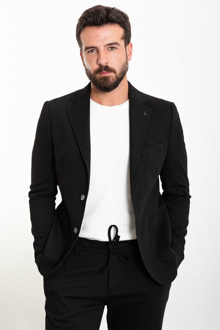 Man wearing a black casual summer suit, blending modern style with comfort for warm-weather occasions.