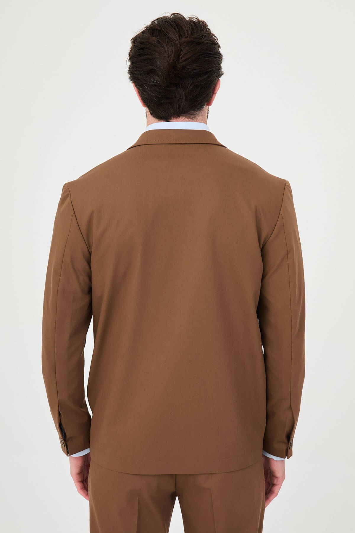 Man wearing a camel slim-fit two-piece suit, tailored for summer, standing outdoors, front view.