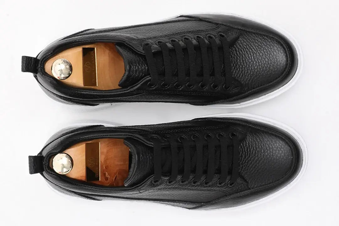 Black leather sneakers with white EVA sole.