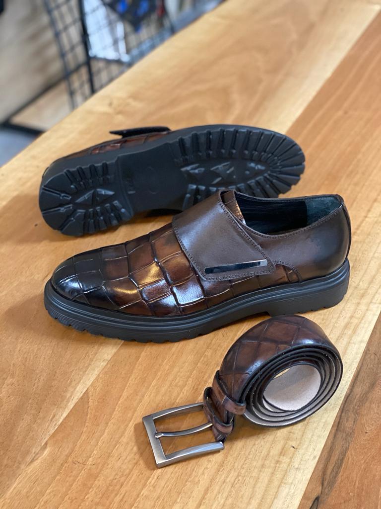 Premium brown calf leather monk strap shoe with buckle detail, showcased at an angle on a wooden surface, emphasizing its elegant design and durable EVA sole