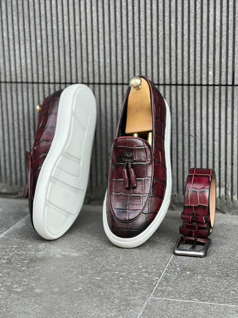 Burgundy leather slip-on loafers with tassel detail and a white EVA sole, offering a sleek and versatile style for warm seasons.