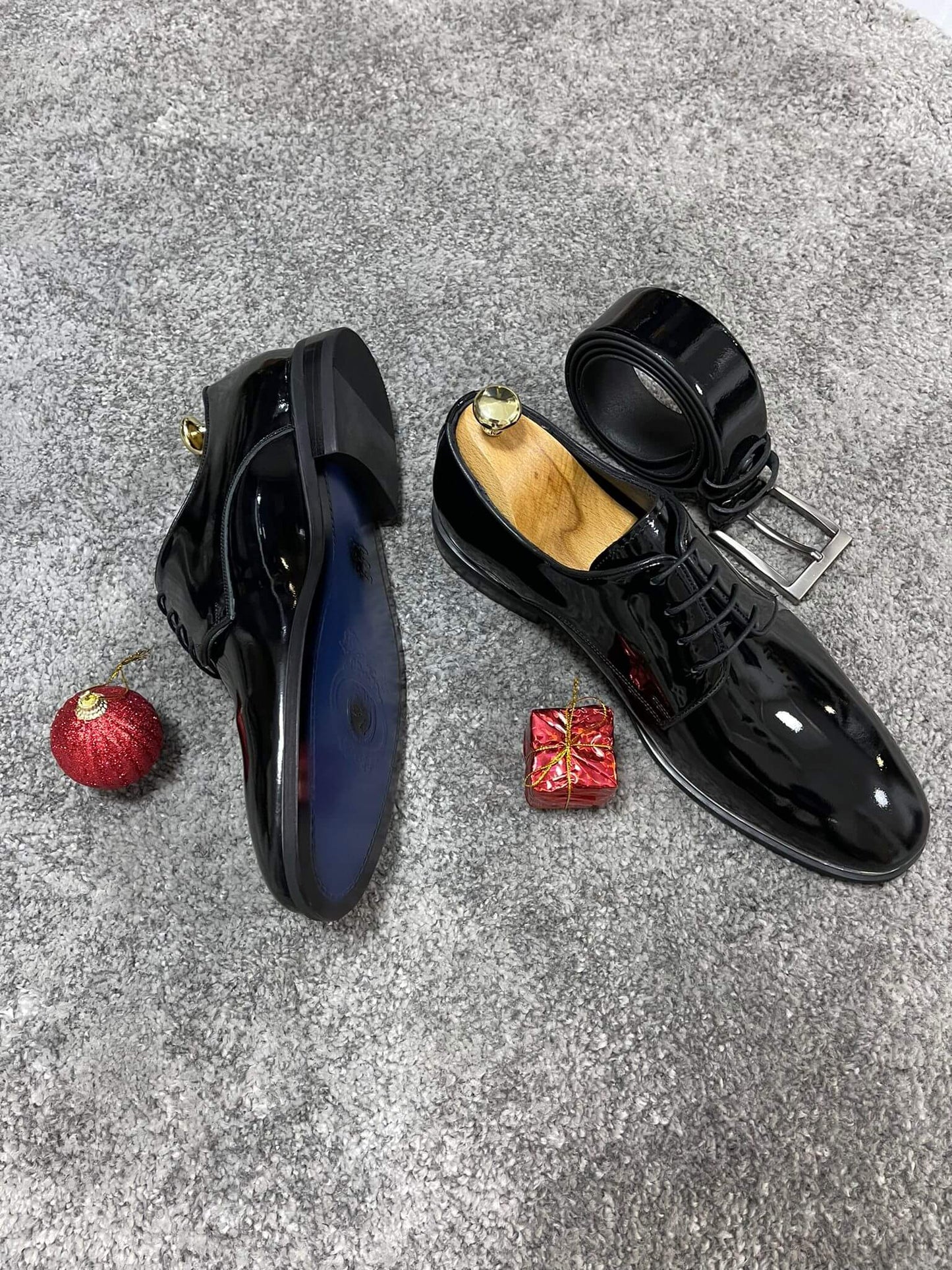 Glossy black patent leather derby shoes with lace-up detail, perfect for formal events and polished fall-winter outfits.
